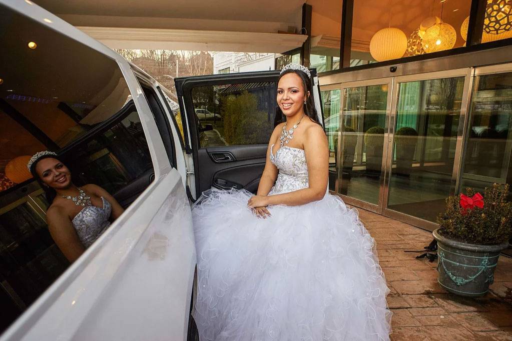 A girl in a gown is getting into a car at the Royal Regency Hotel in Yonkers, NY