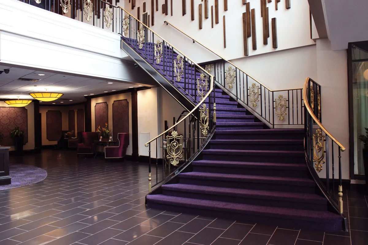 Elegant hotel lobby with grand purple staircase, gold railings in Yonkers, NY