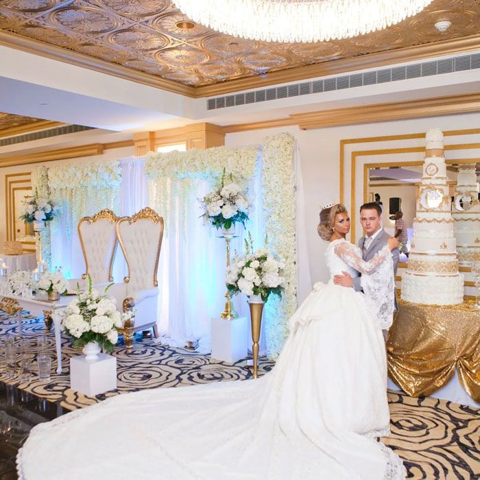 Luxury wedding reception with couple, floral decor, and elegant cake display in Yonkers, NY