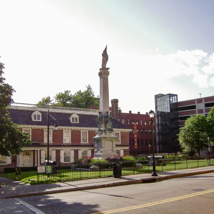 Philipse Manor Hall, with a monument column and a historic brick building in Yonkers, NY