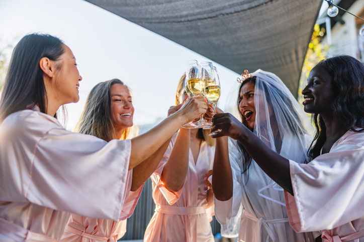 Bridal shower celebration with people in matching robes toasting with glasses in Yonkers, NY